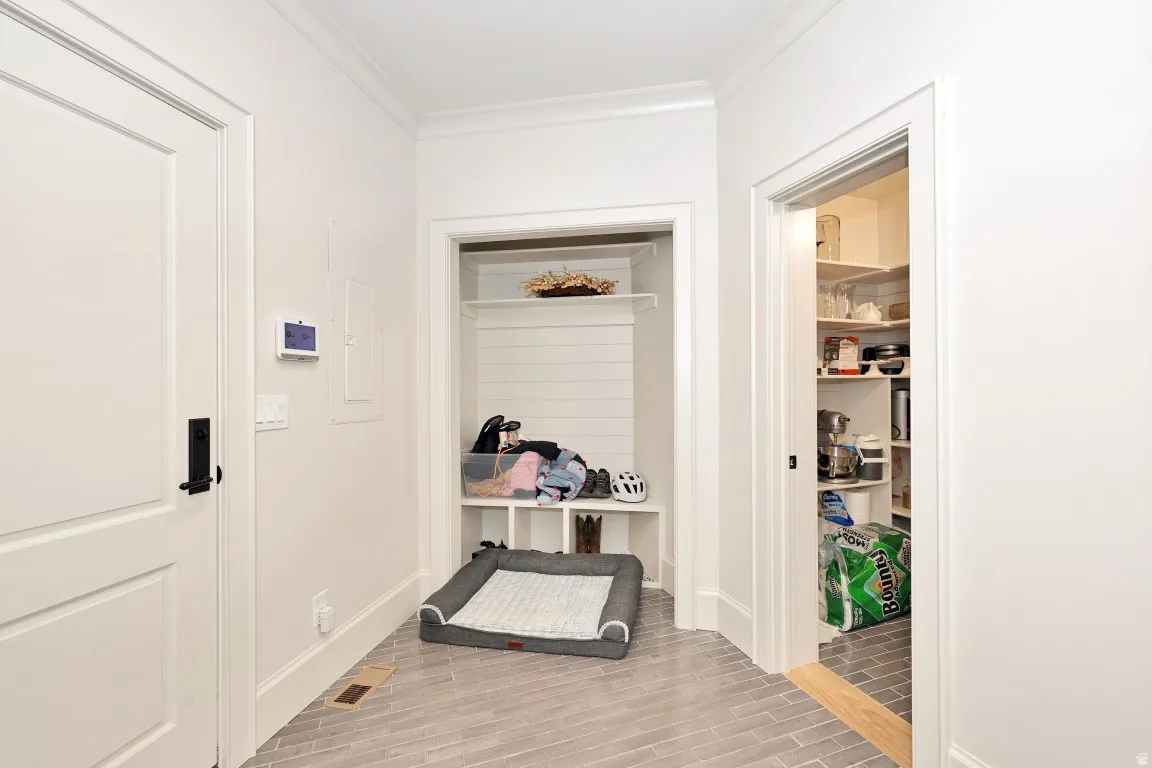 Herringbone-patterned floor tile, built-in shelving with shiplap backing, and a walk-in pantry with solid shelving