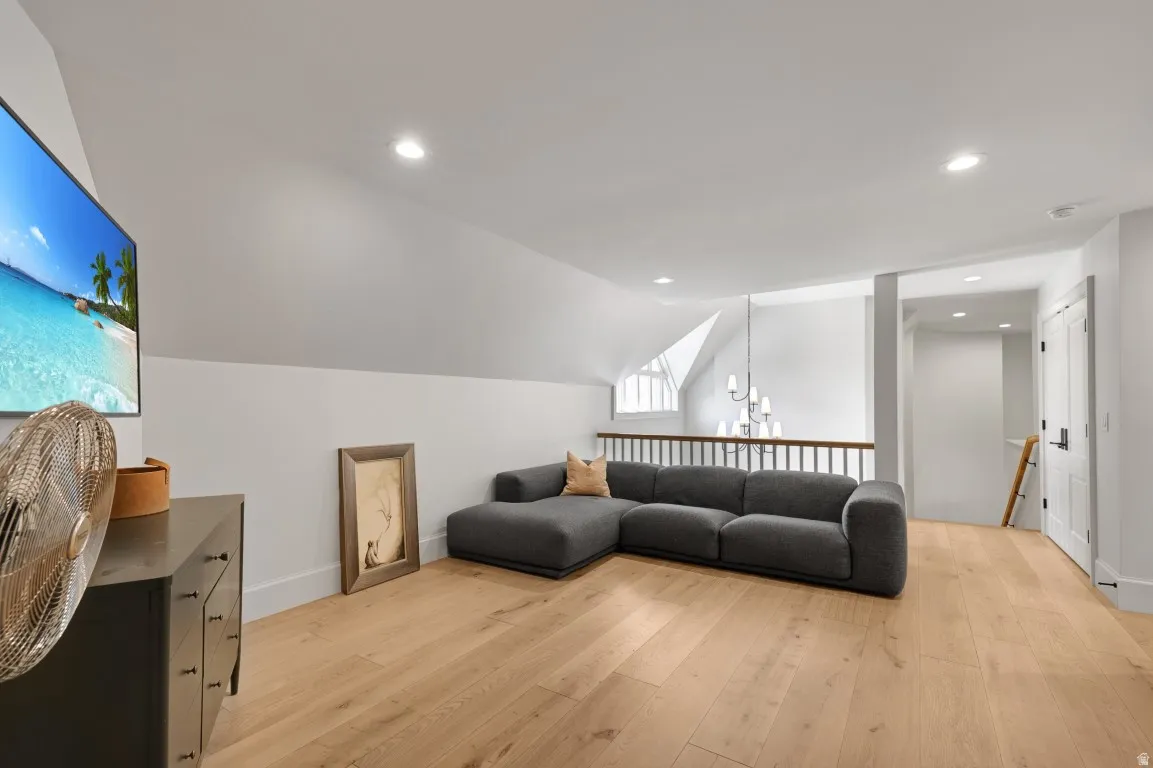 Hardwood-finish flooring, recessed lighting, and a white baluster railing