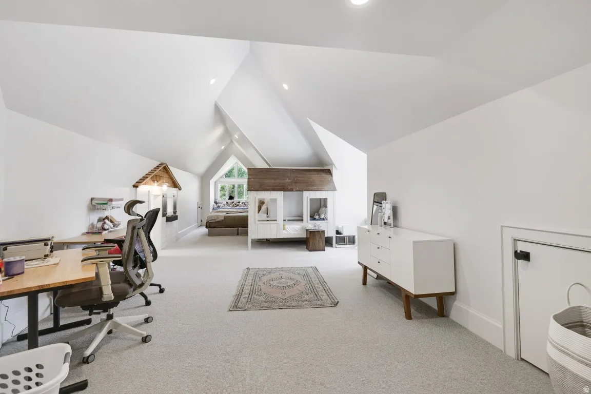 Vaulted ceilings with recessed lighting, light-toned carpeting, and a built-in window seat
