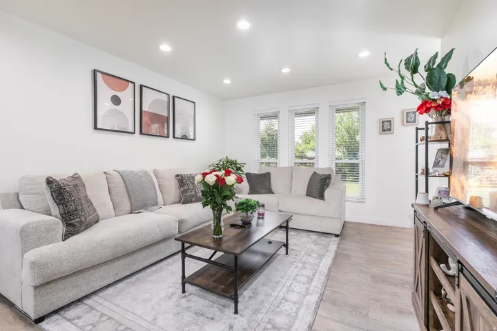 Recessed lighting, wood-finish flooring, multiple windows with blinds, and white wall finishes