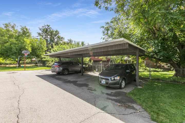 Two-car carport with paved parking area and mature trees