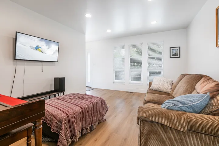 Recessed lighting, wood-finish flooring, and multiple windows with horizontal blinds