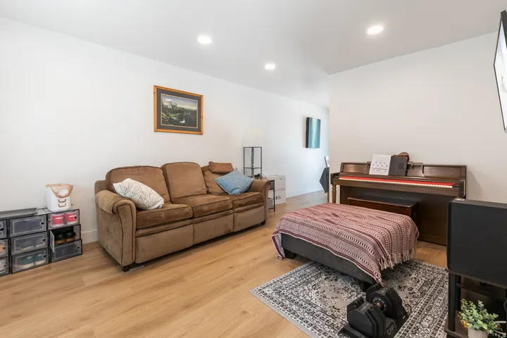 Recessed ceiling lighting, wood-finish flooring, and white walls