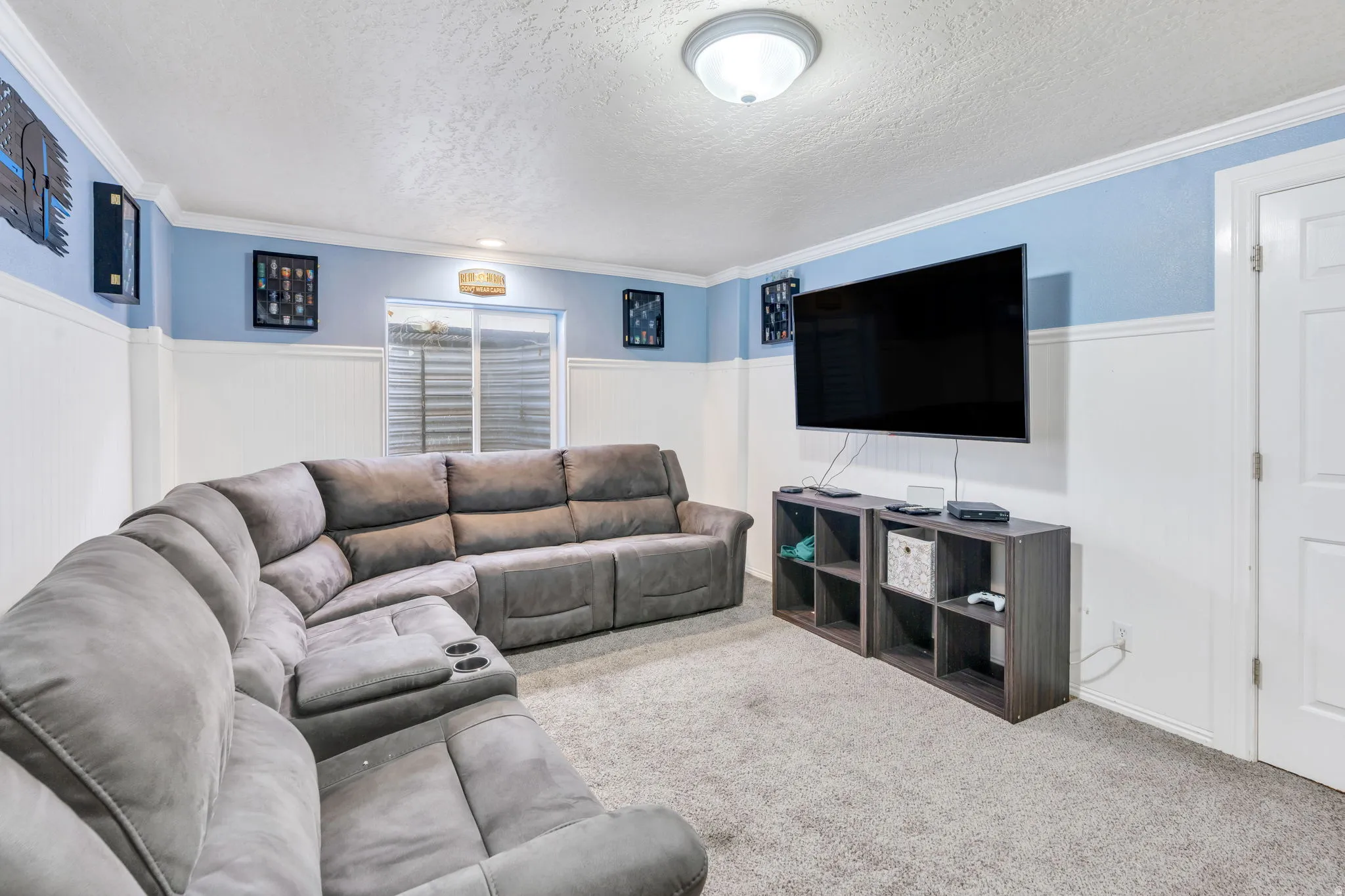 Carpeted room with wainscoting and crown molding