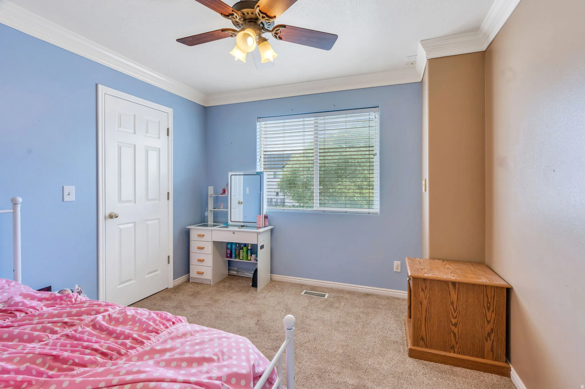Carpeted flooring with multi-tone wall finishes and a ceiling fan with integrated lighting
