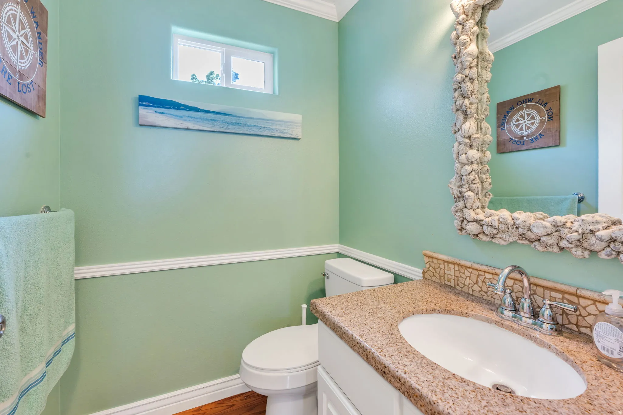 Powder room featuring a white single vanity, granite-finish countertop, and wood-finish flooring