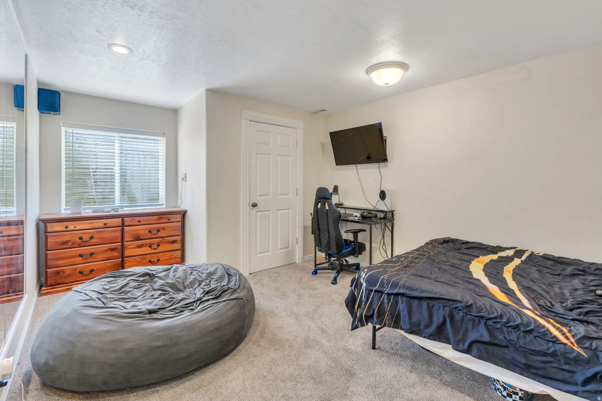 Carpeted flooring, recessed lighting, ceiling-mounted light fixture, window with horizontal blinds, and a paneled door