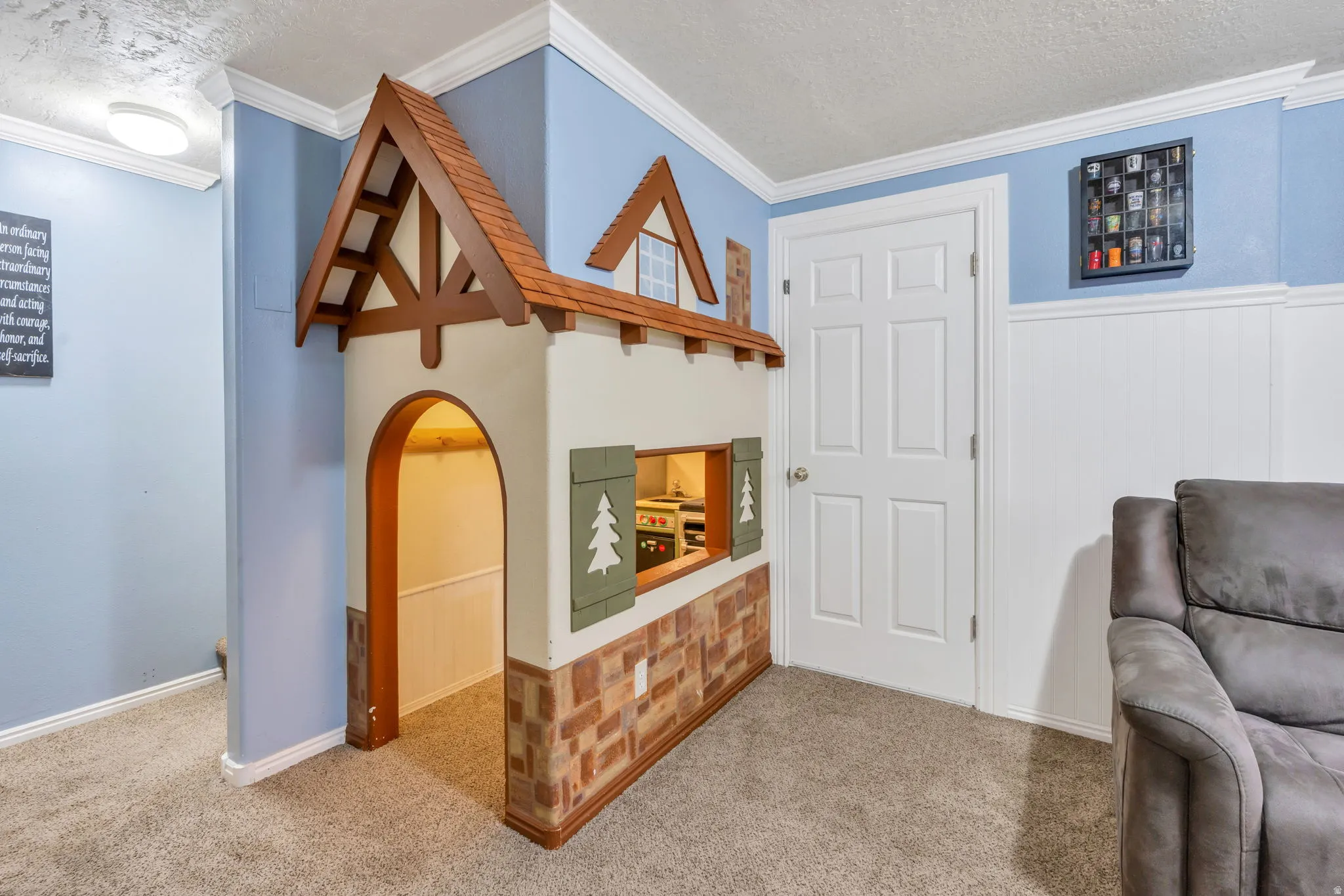 Carpeted flooring, blue wall paint, white wainscoting, and a white six-panel door