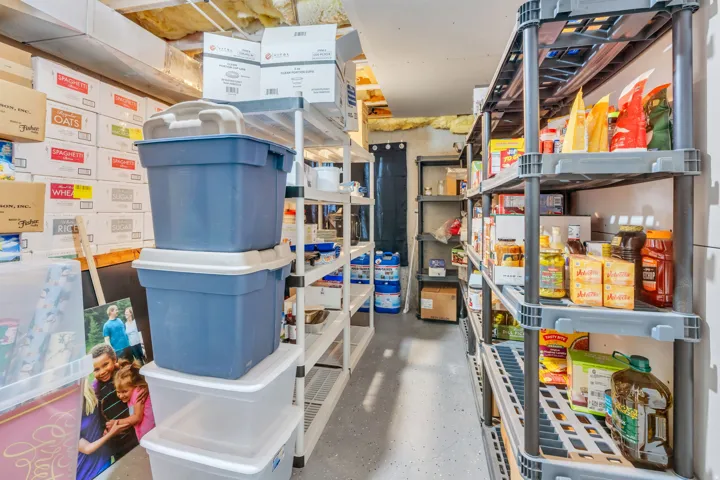 Dedicated storage room featuring multiple shelving units and concrete flooring