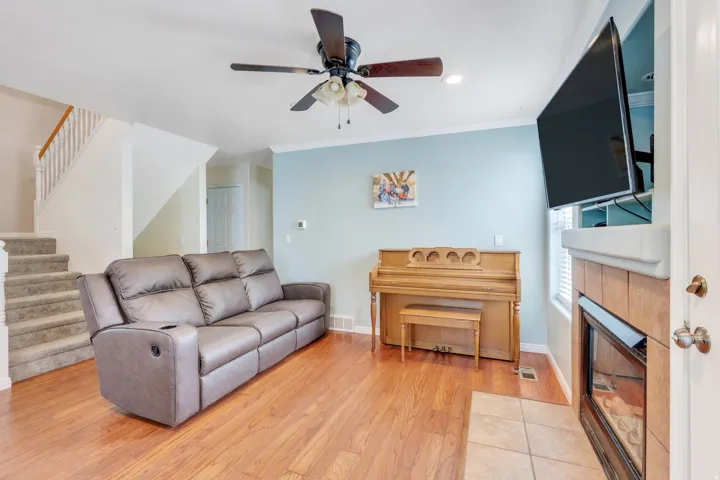 Hardwood-style flooring throughout the main living area, complemented by a ceiling fan with integrated lighting