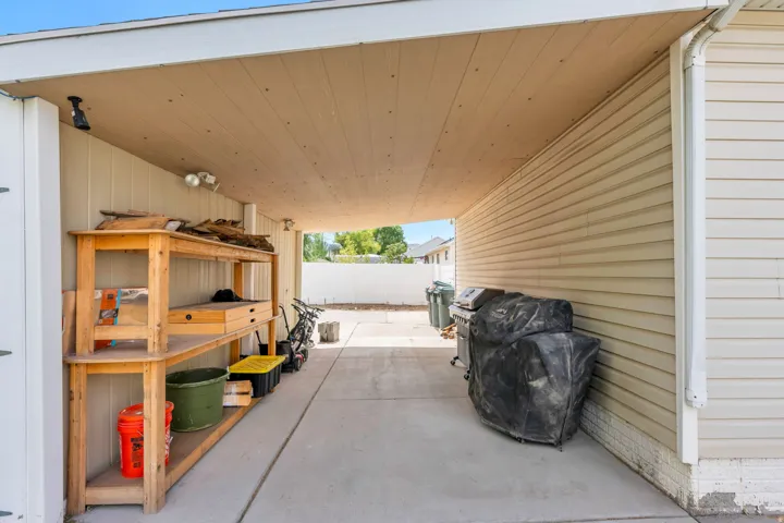 Covered concrete walkway featuring recessed lighting and exterior sconces