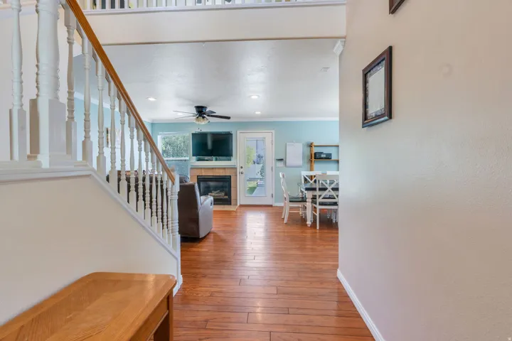 Hardwood-finish flooring throughout, featuring a staircase with white balusters and a wood handrail