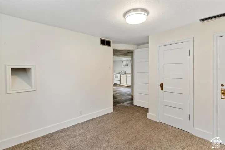Carpeted flooring, built-in wall niche, overhead lighting, and paneled doors with hardware