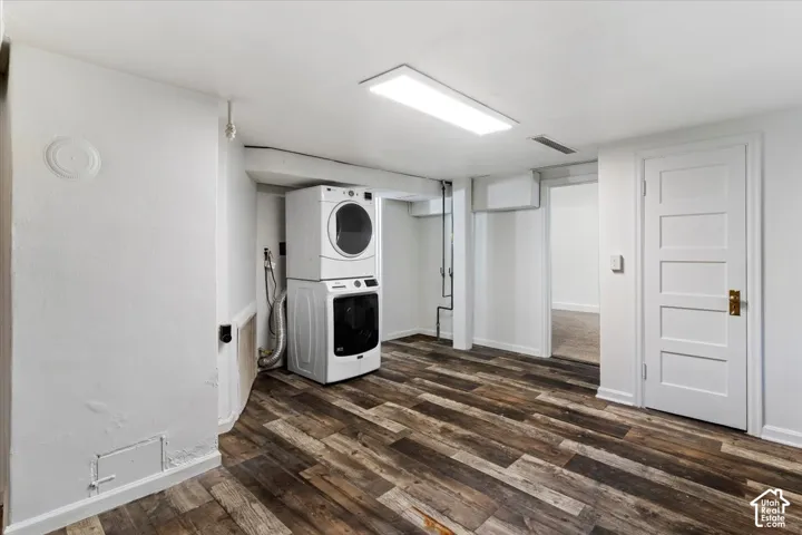 Wood-finish flooring, white paneled door with brass hardware, recessed lighting, and white walls