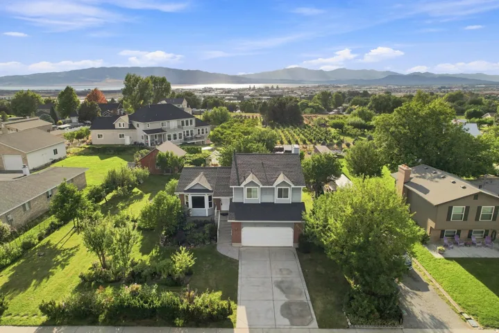 Two-story residence with dormer windows, attached two-car garage, and a paved driveway