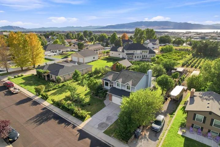 Two-story residence with an attached garage, paved driveway, and mature landscaping