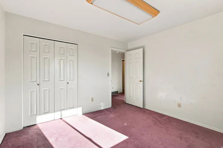 Recessed lighting fixture, paneled bifold closet doors, paneled interior door, and wall-to-wall carpeting