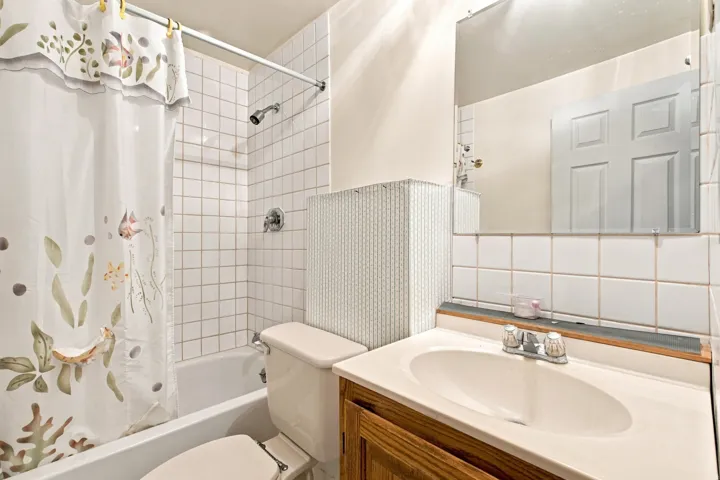 White tiled shower surround with a built-in tub