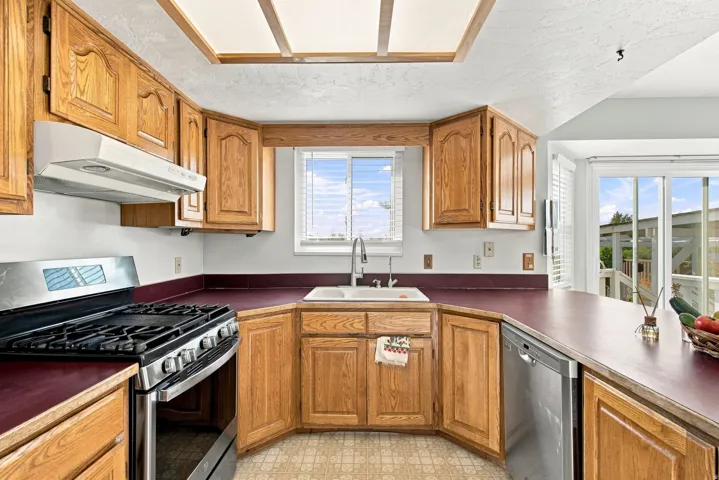 Wood-finish cabinetry paired with a stainless steel range and dishwasher