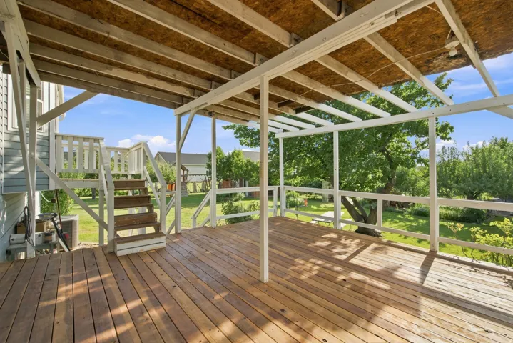 Expansive wood-finish deck with white railings and an integrated pergola