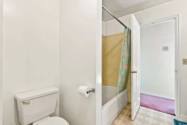 White porcelain toilet with a chrome toilet paper holder