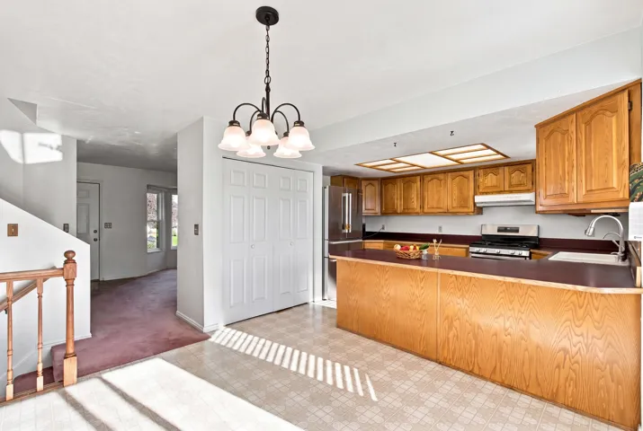 Kitchen featuring wood cabinetry, stainless steel appliances, and a built-in breakfast bar