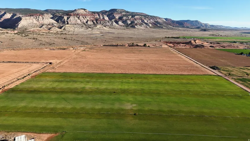 Expansive, cultivated land featuring green fields and arid terrain