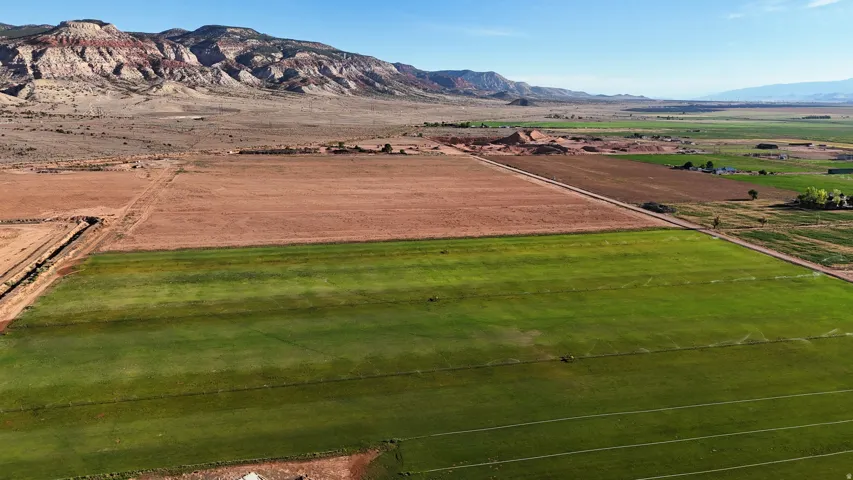 Expansive land parcel featuring cultivated green fields and arid terrain