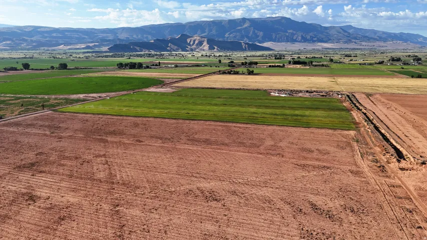 Expansive land parcel featuring cultivated fields and a distant mountain range