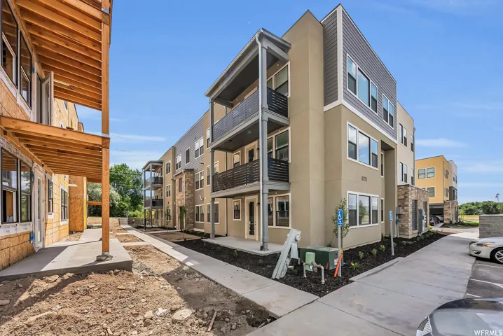 Contemporary exterior with multi-level balconies, stone accents, stucco finish, and siding details