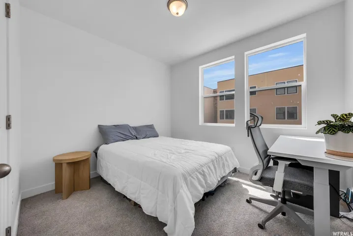 Neutral wall tones, carpeted flooring, and a flush mount ceiling light