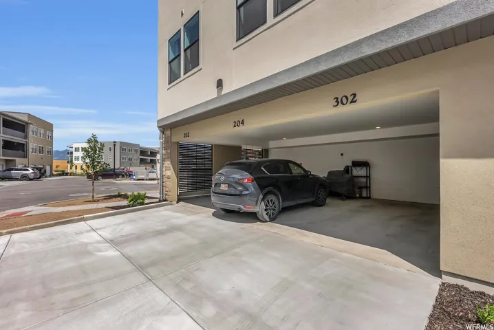 Covered parking garage with concrete flooring and recessed lighting