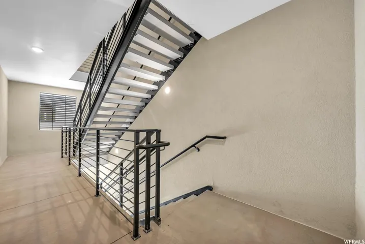 Open-riser staircase with metal railings and a metal handrail