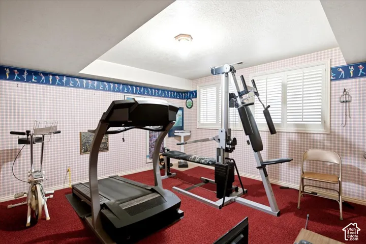 Room featuring red carpeting, two windows with white plantation shutters, and a recessed ceiling light