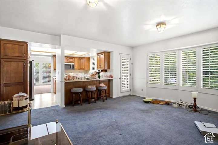 Kitchen with wood cabinetry, integrated microwave, and breakfast bar