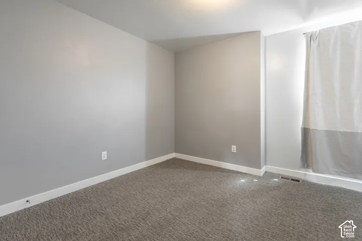 Recessed ceiling lighting, gray wall paint, and plush gray carpet flooring