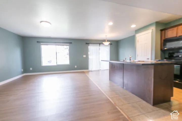 Open-concept living space with wood-finish flooring, a kitchen island, and sliding glass doors