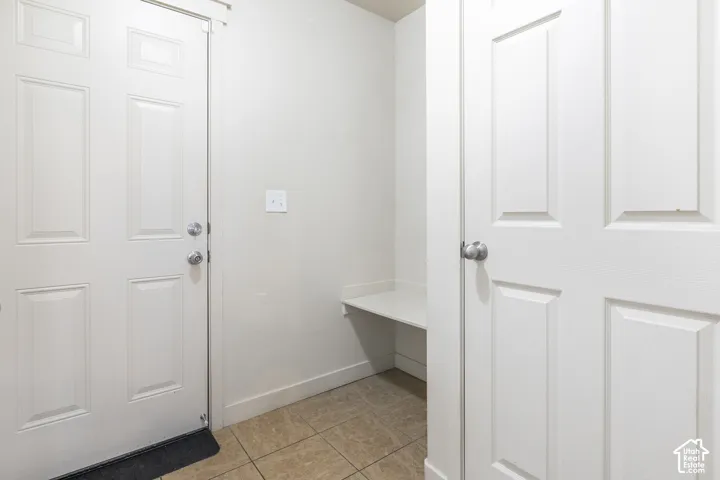 Built-in bench with storage, panel doors, and tile flooring