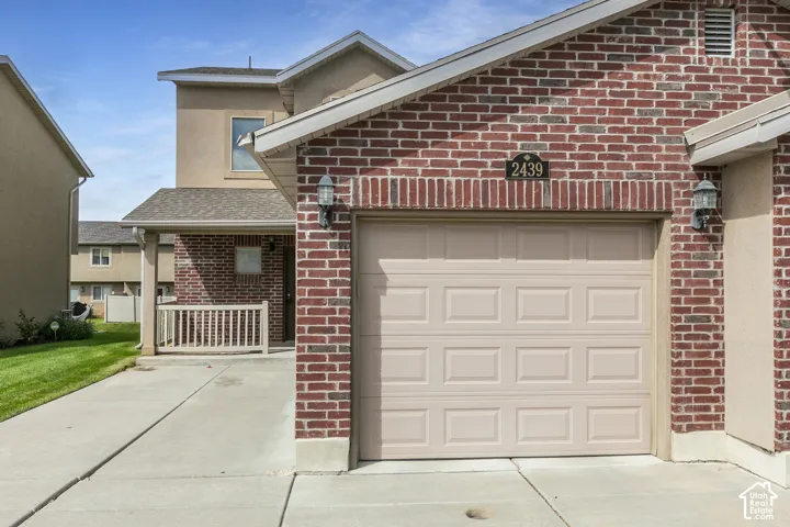 Brick facade with stucco accents and an attached garage