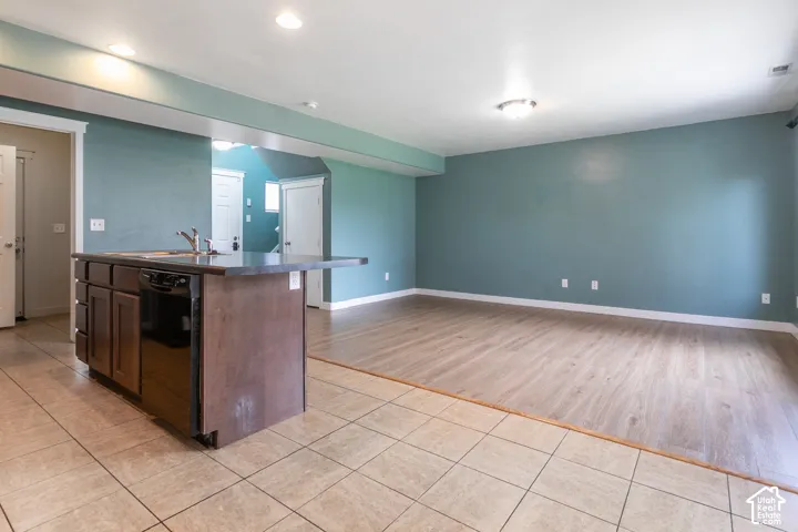 Kitchen island with dark cabinetry and an integrated dishwasher