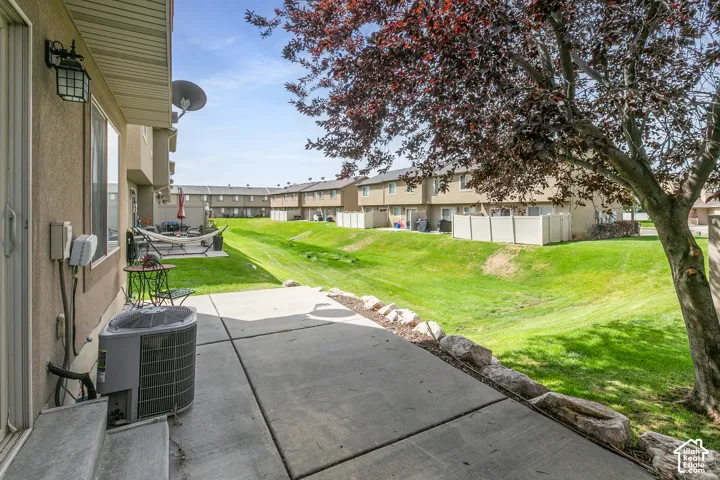 Concrete patio with a rock border and a manicured lawn