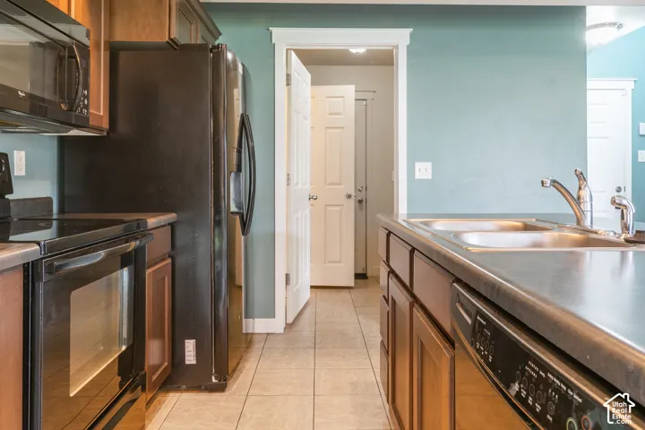 Kitchen featuring a dual basin sink, stainless steel faucet, and tile flooring