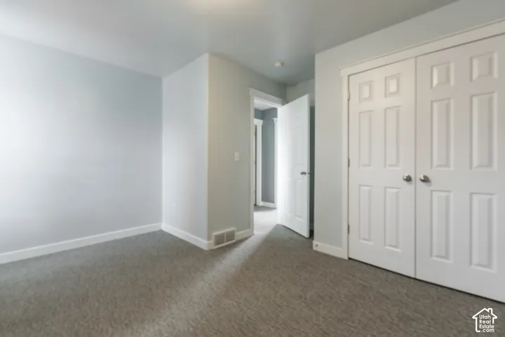 Neutral wall tones, gray carpeting, white trim, and white paneled doors