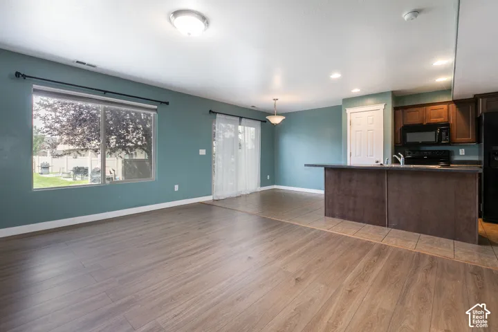 Wood-finish flooring throughout, complemented by a large window and sliding glass door