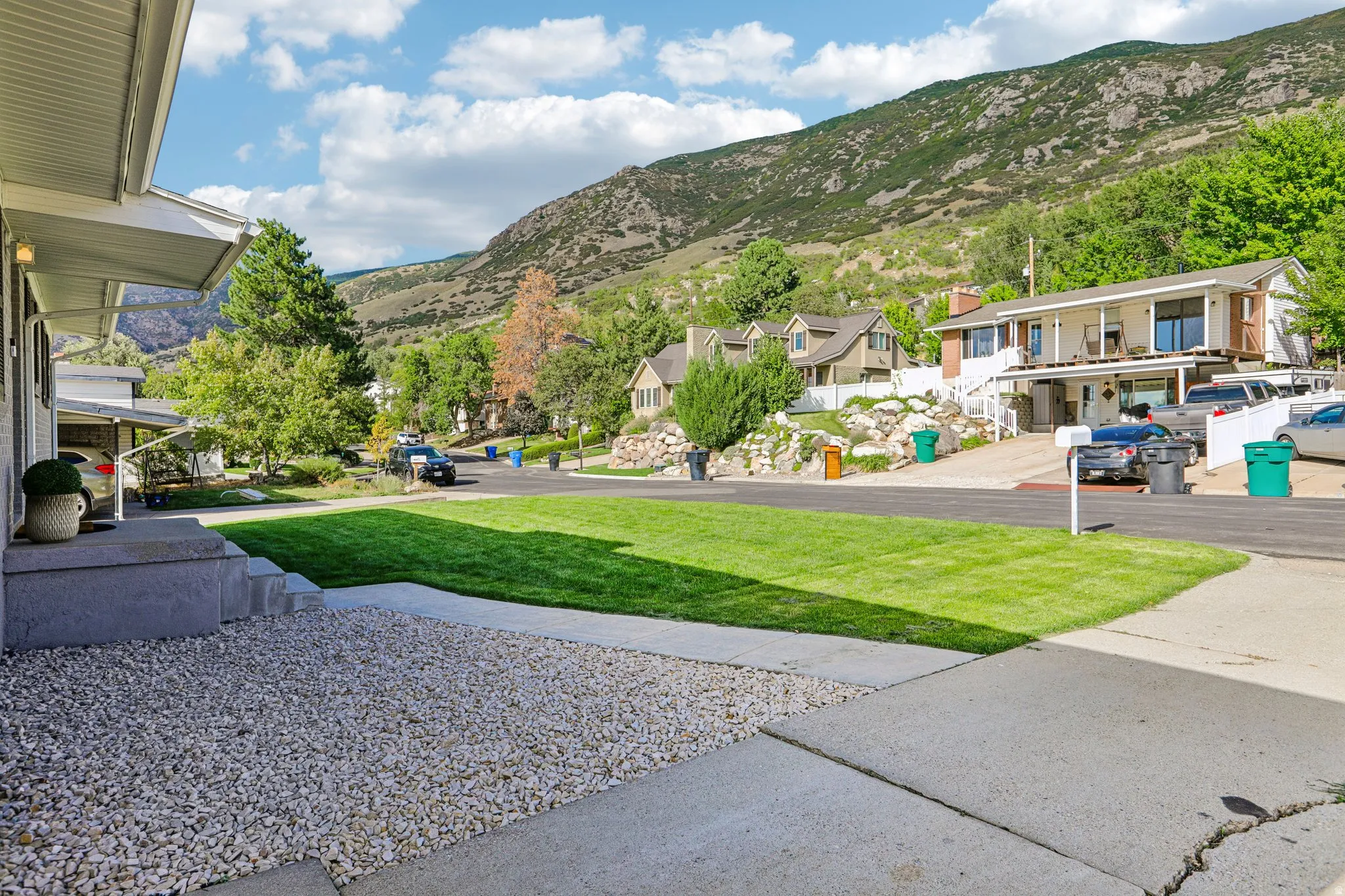 Manicured front lawn with a concrete walkway and gravel landscaping