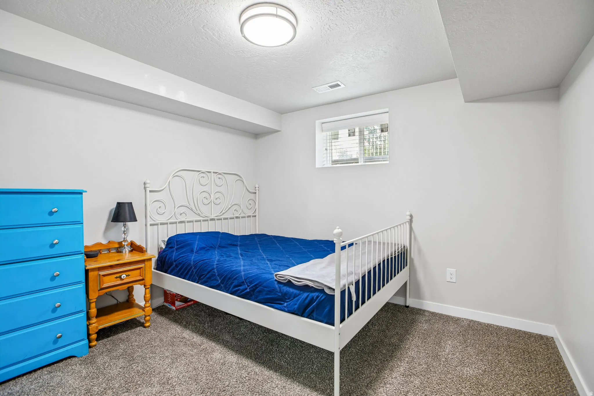 Plush carpet flooring, recessed window, and overhead lighting