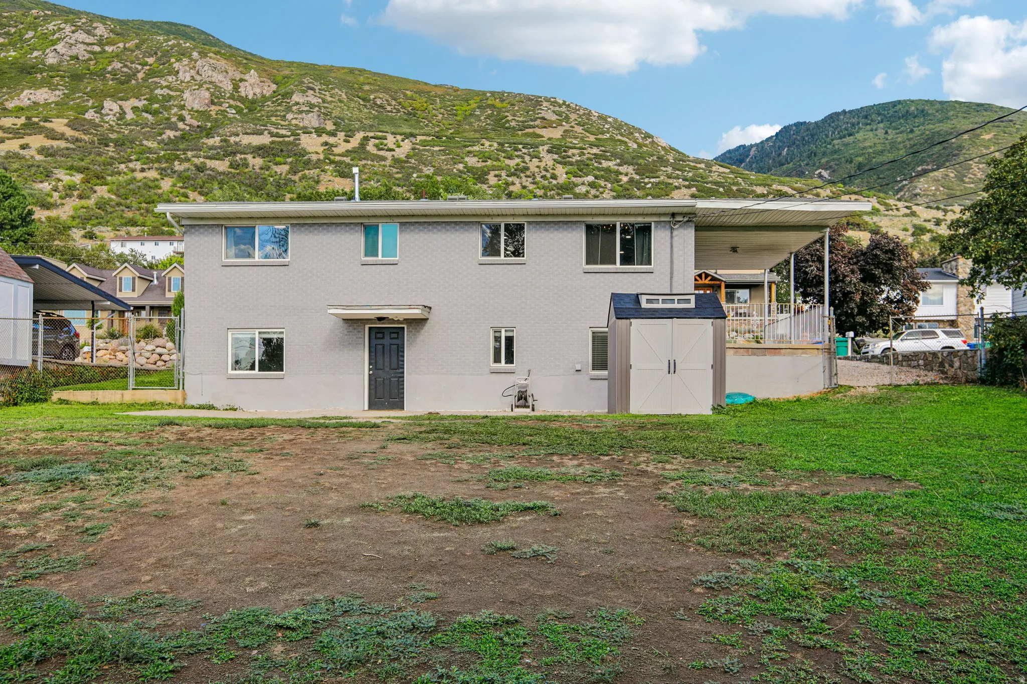 Rear exterior with a covered patio and a detached storage shed