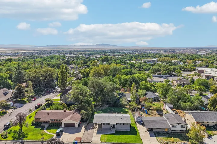 Residential neighborhood setting with mature trees and mountain backdrop