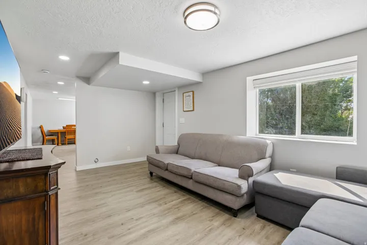 Recessed lighting, wood-finish flooring, and a large window with natural light