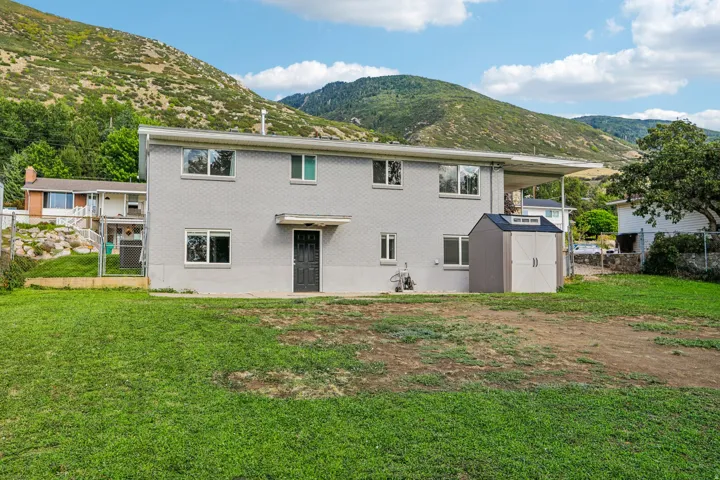Two-story exterior with a covered patio and a separate storage shed
